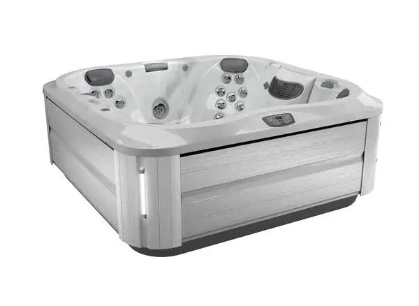 A white rectangular hot tub with rounded corners, equipped with multiple built-in jets and padded headrests. The J-335 COMFORT HOT TUB WITH OPEN SEATING, featuring Jacuzzi® PowerPro® jet technology, has a digital control panel on the side and boasts sleek, modern design details including a light gray exterior finish.