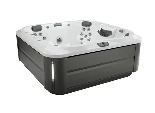 A high-end, square, outdoor hot tub with a white interior and a dark gray exterior. The J-335 COMFORT HOT TUB WITH OPEN SEATING by Jacuzzi features Jacuzzi® PowerPro® jet technology, multiple jet nozzles, headrests, and control buttons on the side. The design appears modern with clean lines and comfortable seating.