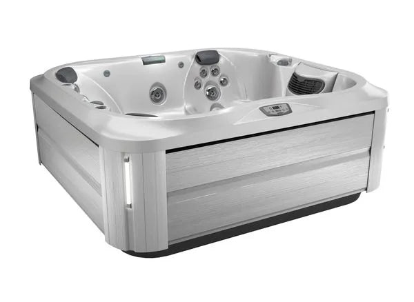 A modern, square-shaped Jacuzzi J-355 HOT TUB WITH COMFORT LOUNGE SEATING & COOL DOWN SEAT with multiple hydrotherapy jets and seating areas. The exterior is finished in a light grey, wood-like material. The hot tub features integrated controls, headrests for comfort, and a ProClear filtration system for crystal-clear water.