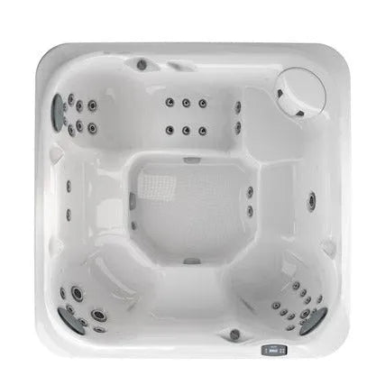 A top view of an empty white square J-275 CLASSIC LARGE HOT TUB WITH LOUNGE SEAT - NEW MODEL by Jacuzzi with multiple jet outlets on the sides and seats, featuring a small round built-in pillow section in one corner, a control panel on the top right edge, and equipped with the CLEARRAY® UV-C system for cleaner water.