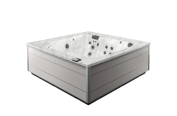 An image of a modern, square-shaped Jacuzzi - J-LXL Hot Tub with sleek gray paneling and multiple water jets on the interior surfaces, designed for hydrotherapy. The Jacuzzi hot tub appears to be empty and is placed against a plain white background.