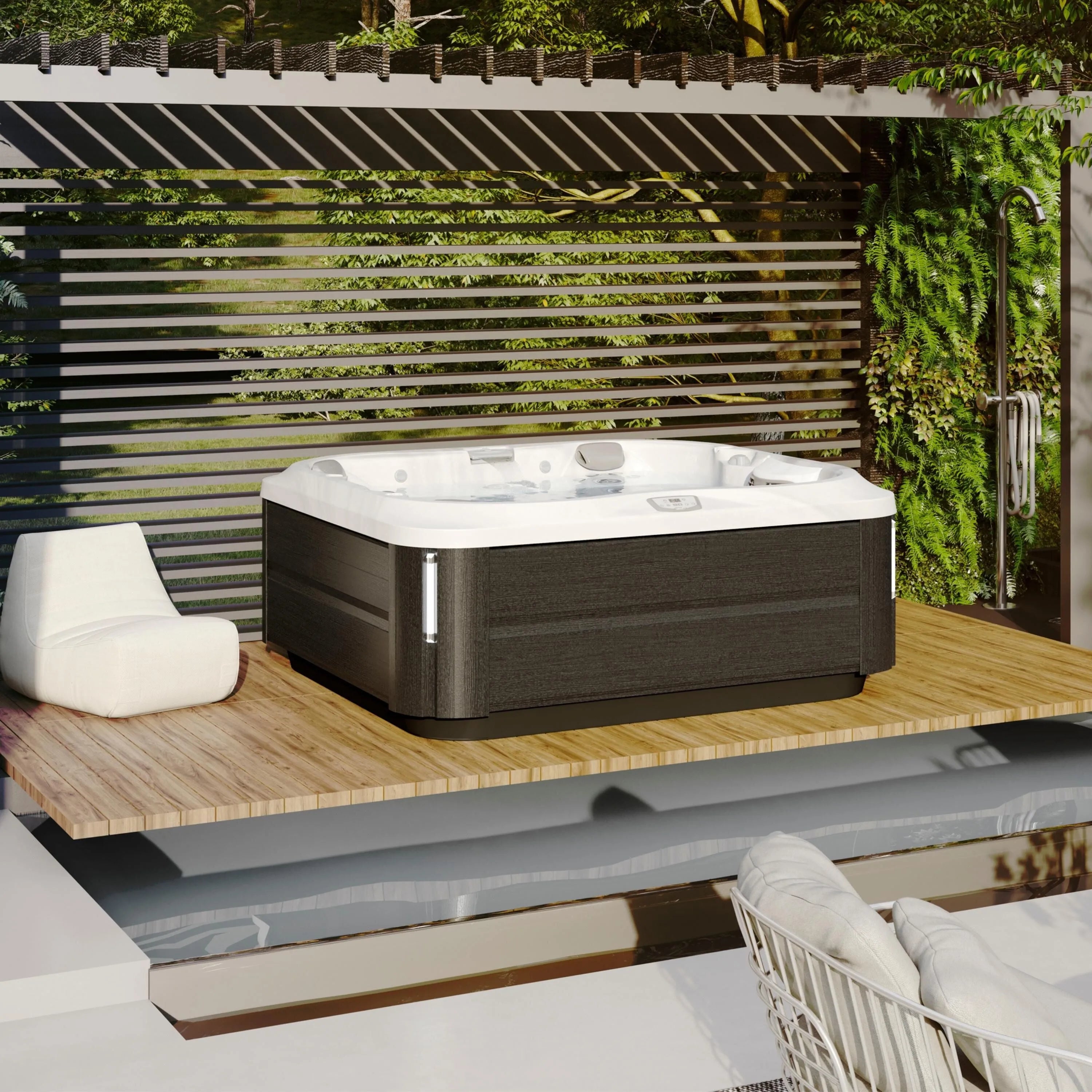 A modern outdoor deck features a square Jacuzzi J-355 HOT TUB WITH COMFORT LOUNGE SEATING & COOL DOWN SEAT with a white interior and dark wood exterior, enhanced by hydrotherapy jets. The deck has wooden slats on one side, greenery on the walls, a cozy white chair, and a rain shower fixture. The elegant setup is surrounded by a lush garden.