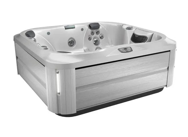 A modern, square-shaped Jacuzzi J-355 HOT TUB WITH COMFORT LOUNGE SEATING & COOL DOWN SEAT with multiple hydrotherapy jets and seating areas. The exterior is finished in a light grey, wood-like material. The hot tub features integrated controls, headrests for comfort, and a ProClear filtration system for crystal-clear water.
