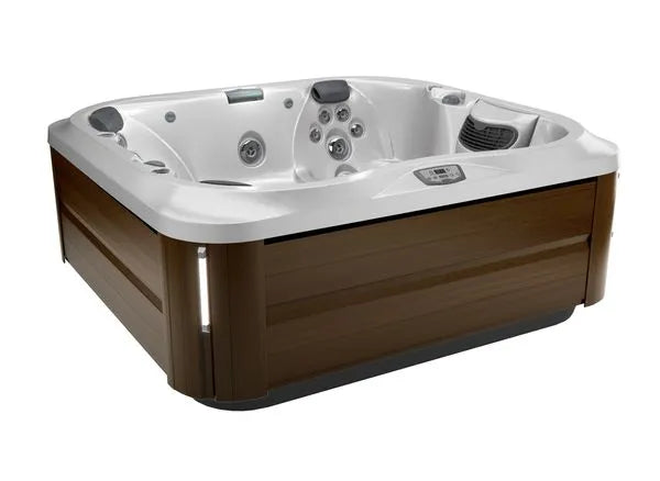 A square Jacuzzi J-355 HOT TUB WITH COMFORT LOUNGE SEATING & COOL DOWN SEAT with a wooden exterior and a white interior, featuring multiple hydrotherapy jets and controls on the rim for adjusting settings. The sleek, modern design includes a small display panel on one side and incorporates the ProClear filtration system for crystal-clear water.