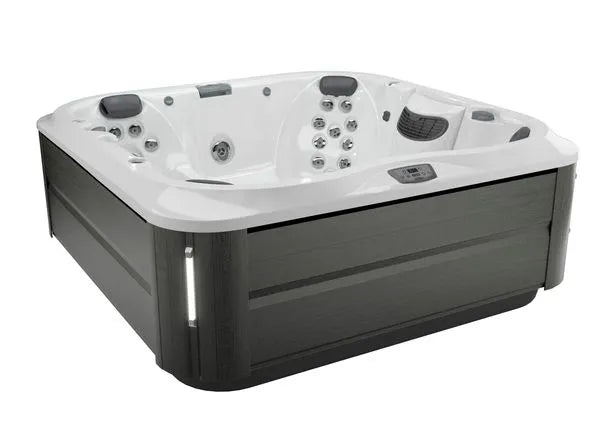 Image of a large, square J-375 COMFORT HOT TUB WITH LARGEST LOUNGE SEAT NEW by Jacuzzi with multiple built-in jets, headrests, and digital controls. The exterior is gray with a modern finish, and the interior is white with ergonomic seating designed for multiple people. Ideal for both indoor and outdoor installation.