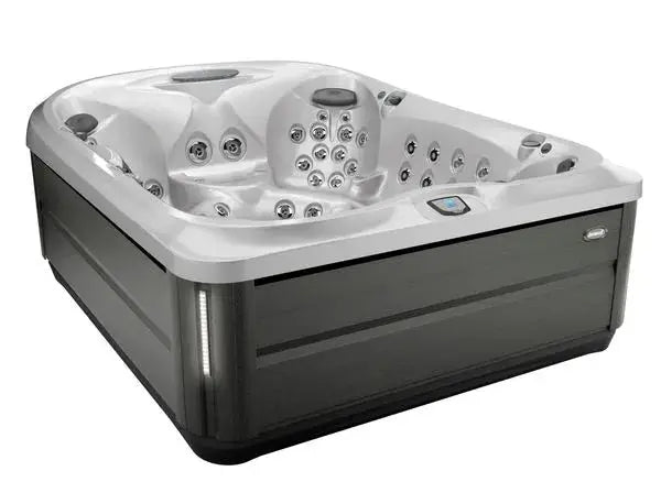 A square, modern Jacuzzi J-495™ DESIGNER ENTERTAINER'S HOT TUB WITH INFRARED & RED LIGHT THERAPY - NEW MODEL with a sleek gray and white design is shown. It features multiple PowerPro jets configurations, ergonomically designed seating, and control panels on the interior and exterior. The hot tub's design provides a luxurious, high-tech hydromassage experience.