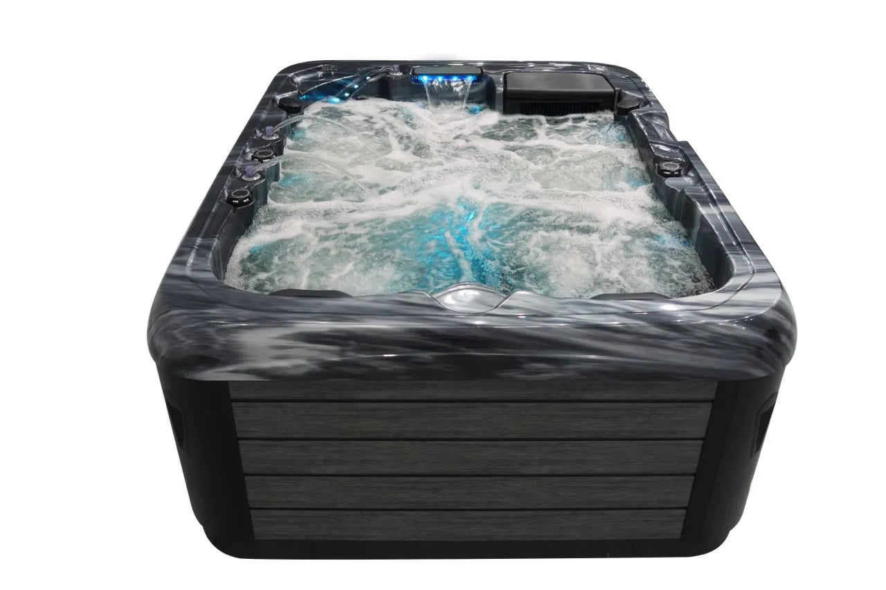 A close-up view of an outdoor Hot Tub Liverpool Atlanta - 2-3 Person Hot Tub filled with bubbling water. The tub features sleek, dark panels on the exterior and customizable jets releasing water into the tub, creating swirling motions. The water appears clean and inviting, with a hint of blue lighting.