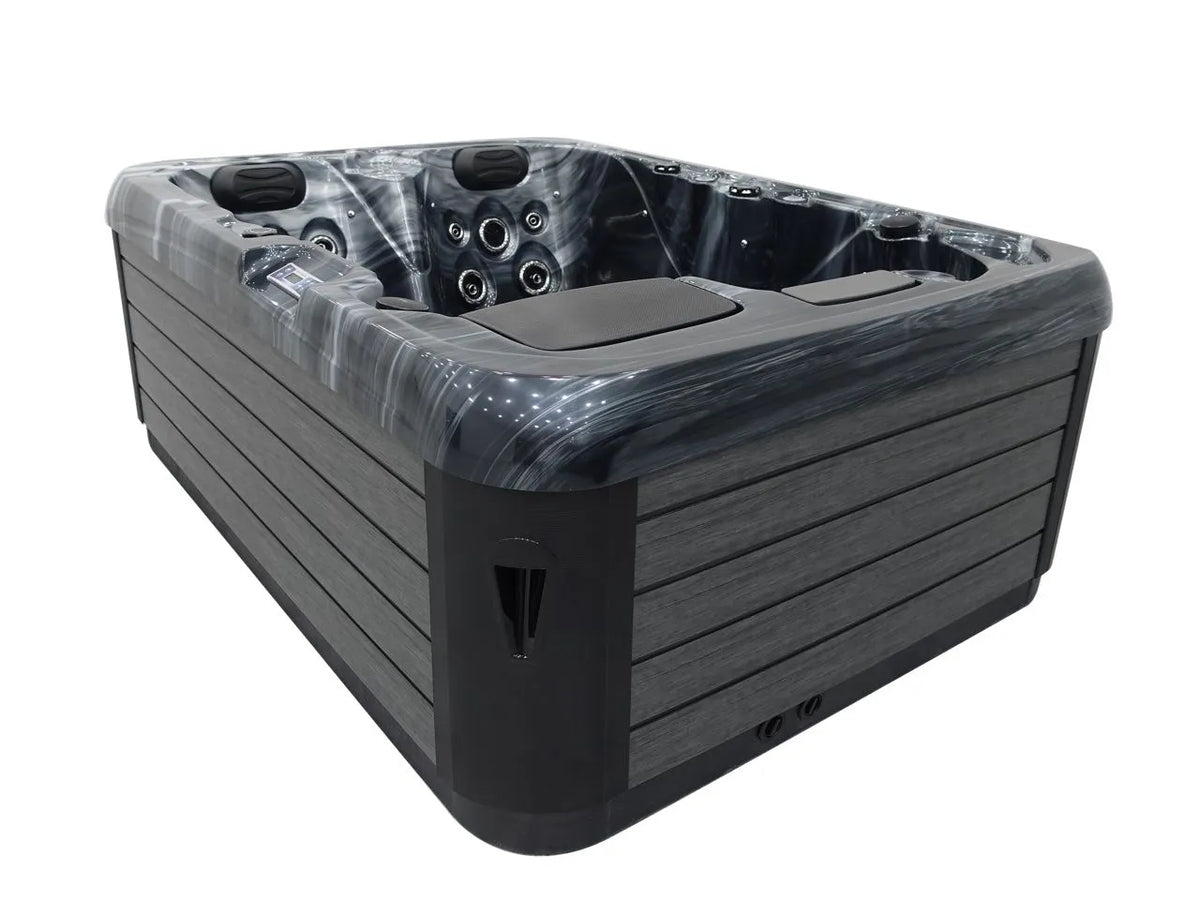 A large, modern Hot Tub Liverpool Atlanta - 2-3 Person Hot Tub with multiple seating areas and numerous customizable jets. The outer panels are a sleek grey with black accents. The interior has a marbled grey finish, providing a luxurious look, and includes cushioned headrests for added comfort.