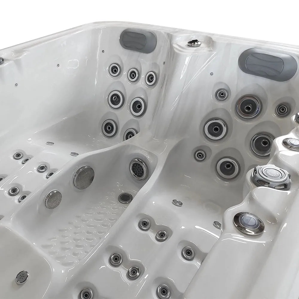 A close-up view of an empty, white, high-end Atlanta - 2-3 Person Hot Tub by Hot Tub Liverpool featuring customizable jets and the advanced Balboa Control System. The hot tub includes various seating and lounging options with different configurations of massage jets for hydrotherapy.