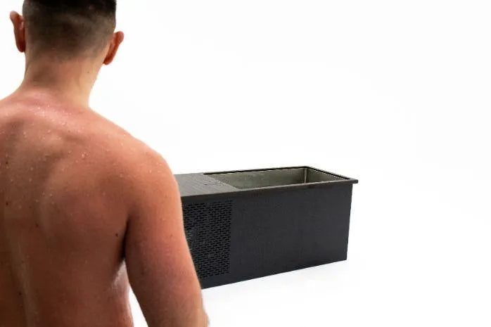A shirtless person with short dark hair stands with their back to the camera, facing a Chill Tubs - Professional affordable Ice Baths ideal for gym fanatics against a white background, ready for cold water therapy.