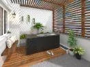A cozy patio with a wooden deck is shaded by a slatted wood pergola. A black outdoor sofa with white cushions sits against a white wall decorated with hanging plants. Potted plants are placed in the corners, and colorful slats create a visually appealing screen, perfect for post-Chill Tubs - Professional affordable Ice Baths ideal for gym fanatics relaxation by Chill Tubs.