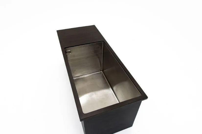 A rectangular, stainless steel sink with a dark, sleek countertop. The image is taken from an overhead angle, showcasing the Chill Tubs' deep bowl and shiny finish. The countertop extends slightly over the Chill Tubs and has a seamless, modern design that could easily double as an ice tub for cold water therapy.
