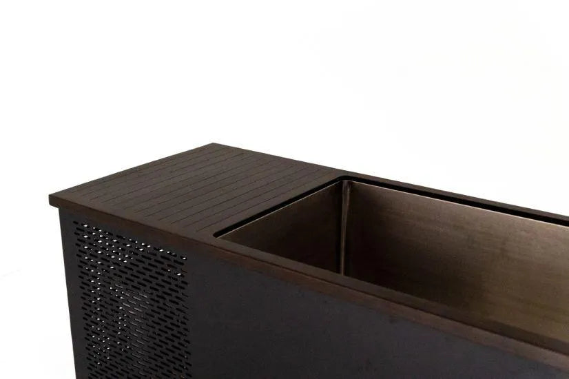 A close-up view of a modern, rectangular metal container with a perforated side panel and a smooth top surface. The container, designed for cold water therapy, has an open compartment with clean, minimalist lines. It is set against a plain, white background. This is the Chill Tubs - Professional affordable Ice Baths ideal for gym fanatics by Chill Tubs.