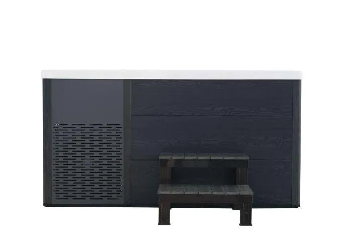 A contemporary black and gray Chillax Ice Bath & Chill Tub Professional affordable wellness Ice Baths & Plunge Pool by Chill Tubs with a white top, featuring a vented panel on the left side. There is a small set of dark wooden steps placed in front, providing access to the ice bath and plunge pool. Perfect for both hot-soaking and cold water immersion, its sleek and minimalistic design caters to all your relaxation needs.