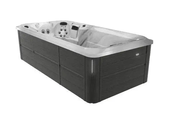 Image of a large, rectangular J-16 Powerpro™ Swim Spa with a sleek, modern design. It features a wood-like exterior and a smooth, molded interior with built-in hydromassage seats and multiple Jacuzzi PowerPro jets. The spa is primarily gray and black, boasting customizable currents and a streamlined, contemporary appearance by Hot Tub Liverpool.