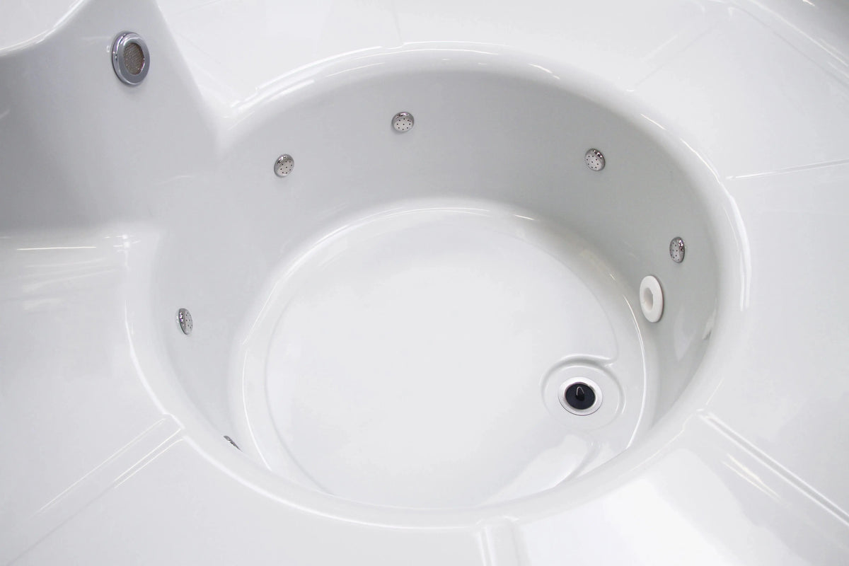 Close-up view of an empty, white jacuzzi tub with multiple jets around its interior. The smooth, clean surface reflects light, emphasizing its glossy finish. This Rexener Polar Wooden Hot Tub - Made in Finland by Hot Tub Liverpool is designed for relaxation and hydrotherapy.