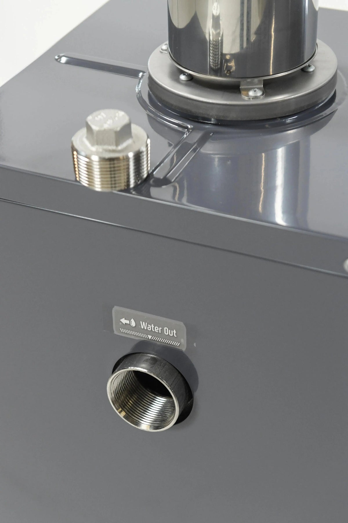 Close-up of a metal industrial component featuring a "Water Out" labeled outlet with threading for connection. The smooth, polished surface exhibits a gray finish, and an adjacent bolt is visible beside the outlet. This design element can be found in energy efficient heaters like the REXENER PR200 energy efficient hot tub water heater from Hot Tub Liverpool.