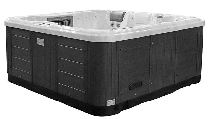 A large, square hot tub with a USA Aristech Acrylic Shell and dark wood-like exterior panels. The Sunbeach Spas - SB349L - Standard - (13 Amp) by Hot Tub Liverpool has several built-in seats, high-performance jets, and Balboa TP500S Control Panel. The outside panels are partially ribbed and feature a small access door on one side.