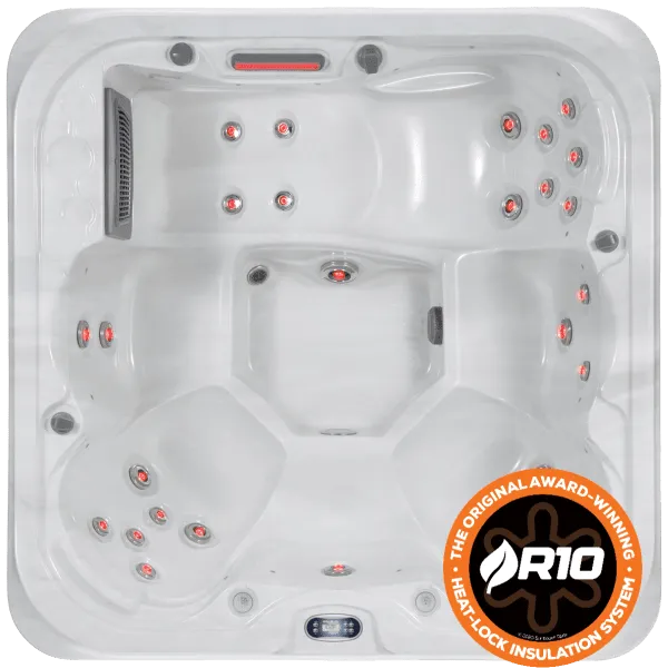 Top view of a white rectangular hot tub with multiple built-in seat areas and red LED lights. The Hot Tub Liverpool Sunbeach Spas - SB353L- Aurora (13Amp), featuring an Aristech Acrylic Shell, has various jet nozzles and buttons. A round badge in the lower right corner reads "R10," highlighting an award-winning HeatLock insulation system.