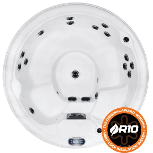 Top view of a white circular hot tub with multiple built-in jet nozzles and a headrest. A small Balboa TP500S Control Panel is visible at the forefront of the tub. There is a brown and white emblem in the bottom right corner indicating an award-winning heatlock insulation system called R10. The product shown is the Sunbeach Spas - SB415R - HSG282 (13 Amp) from Hot Tub Liverpool.